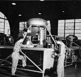 Students study using Training Aids Dept. constructed B-29 Central Fire Control System.  [Wings]