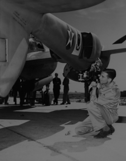 A Photo School student shooting close-ups of a P-38 recon aircraft.  (Wings)