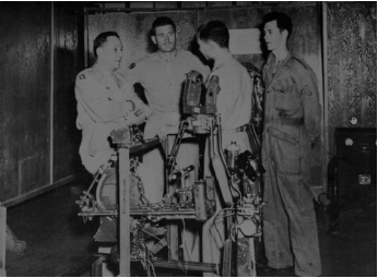 Standing over an intricate Armament Dept. mock-up, Gen. Bres of the ROTC and Lt. Col. Messerschmitt talk with Chinese officer