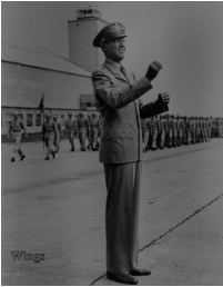 Jimmy Steward in the role of Glenn Miller directs band for a review with Hanger #1 in the background.  [Wings]